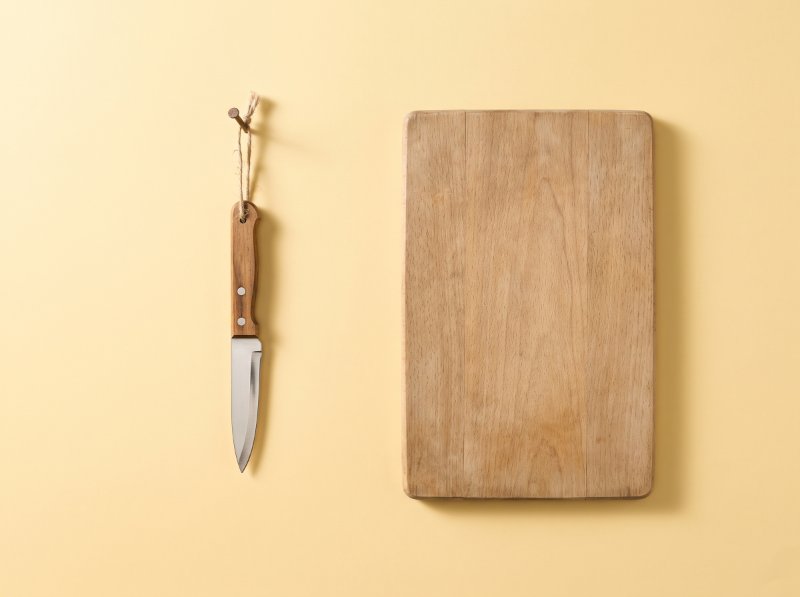 Un couteau d'office accroché au mur, propre, à côté d'une planche vide